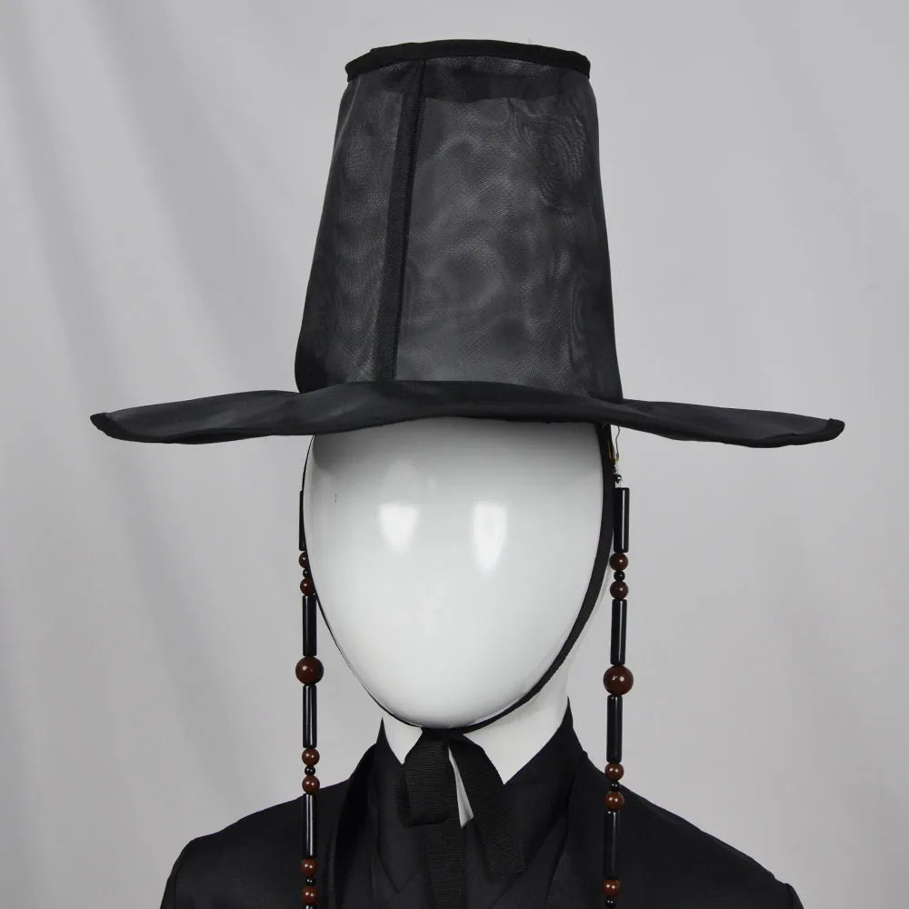 Black traditional hat on a mannequin head against a gray background