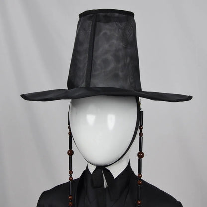 Black traditional hat on a mannequin head against a gray background