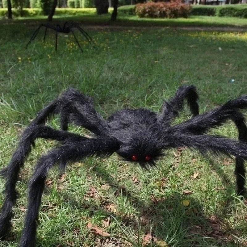 Large black spider decoration on grass
