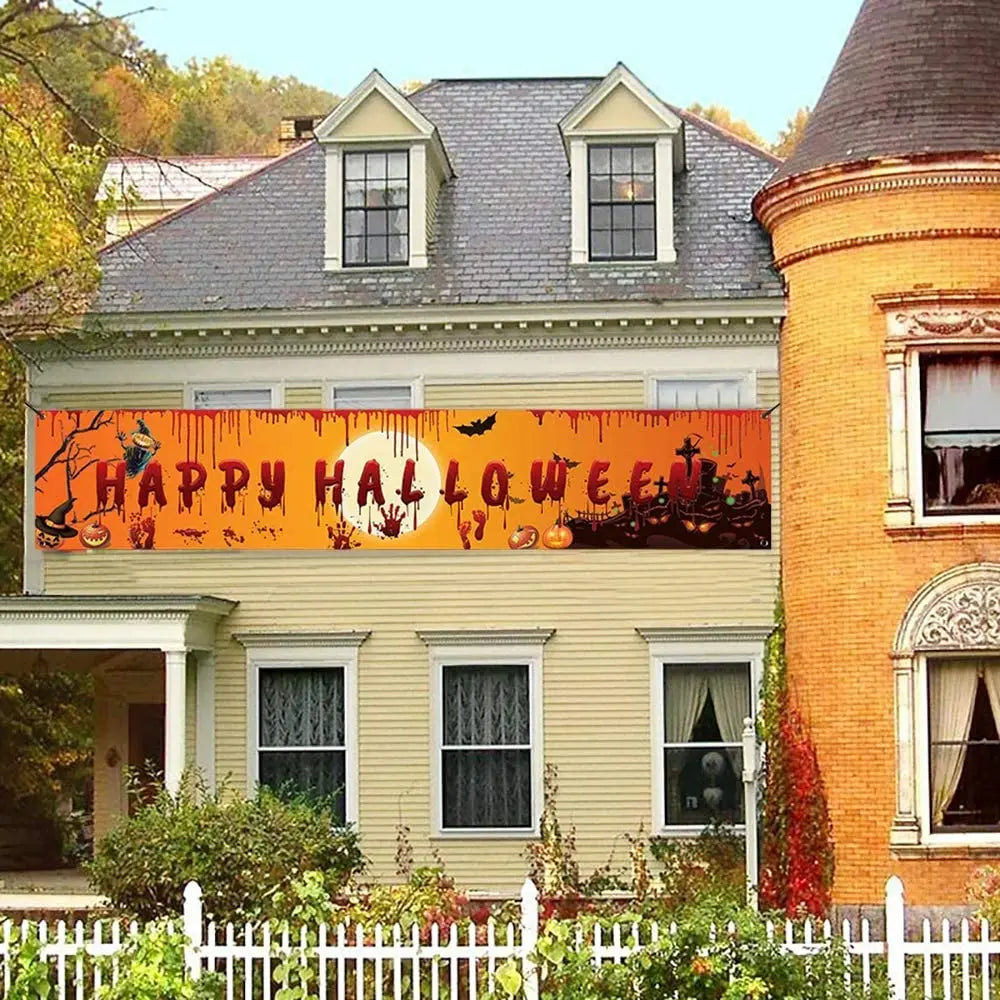 Halloween banner on a house exterior with pumpkins, ghosts, and bats.
