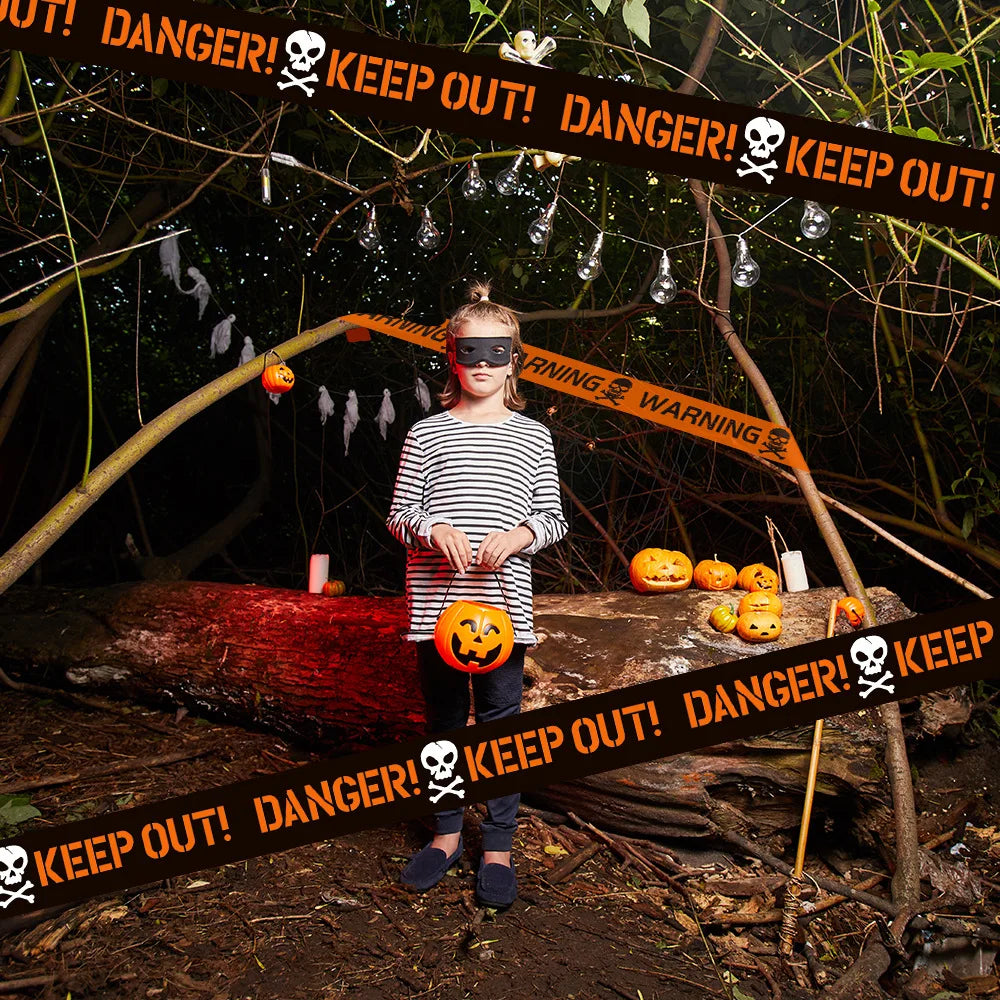 Person wearing a striped shirt and blindfold standing in a Halloween-themed setting with pumpkins and 'Keep Out!' signs.