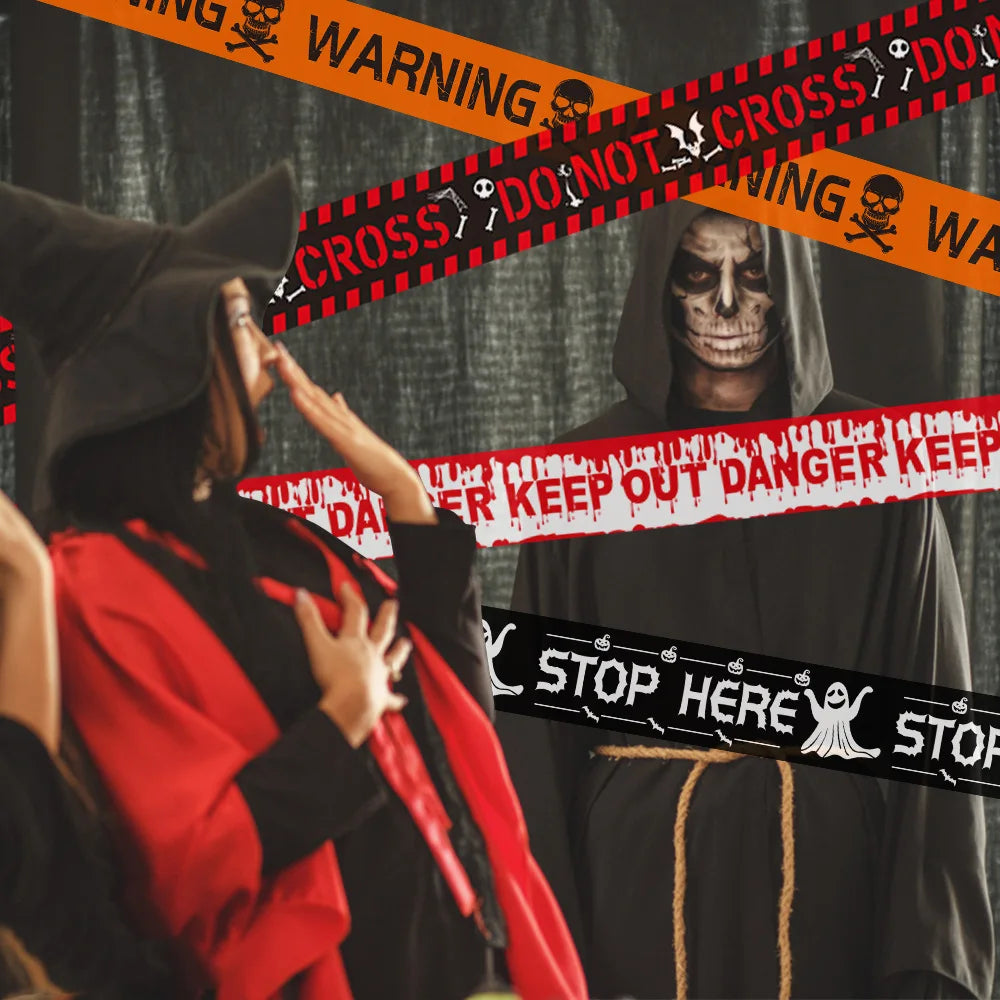 Person in a red cape and black hat pointing at a skeleton in a hooded cloak with warning tapes.