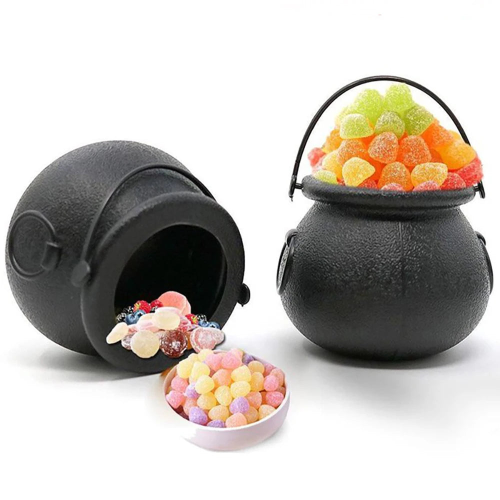 Black cauldron-shaped candy container with colorful gummy candies on a white background