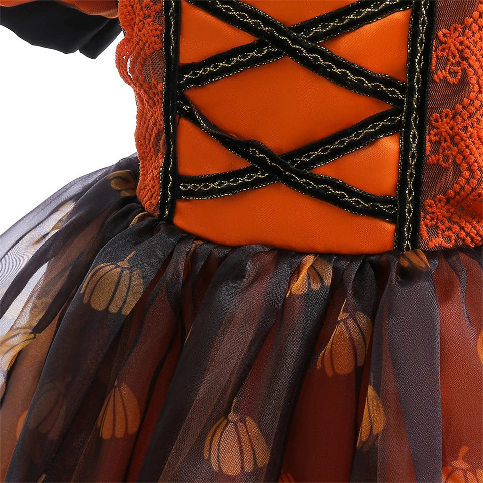 Close-up of a Halloween-themed dress with orange top and pumpkin patterned skirt.